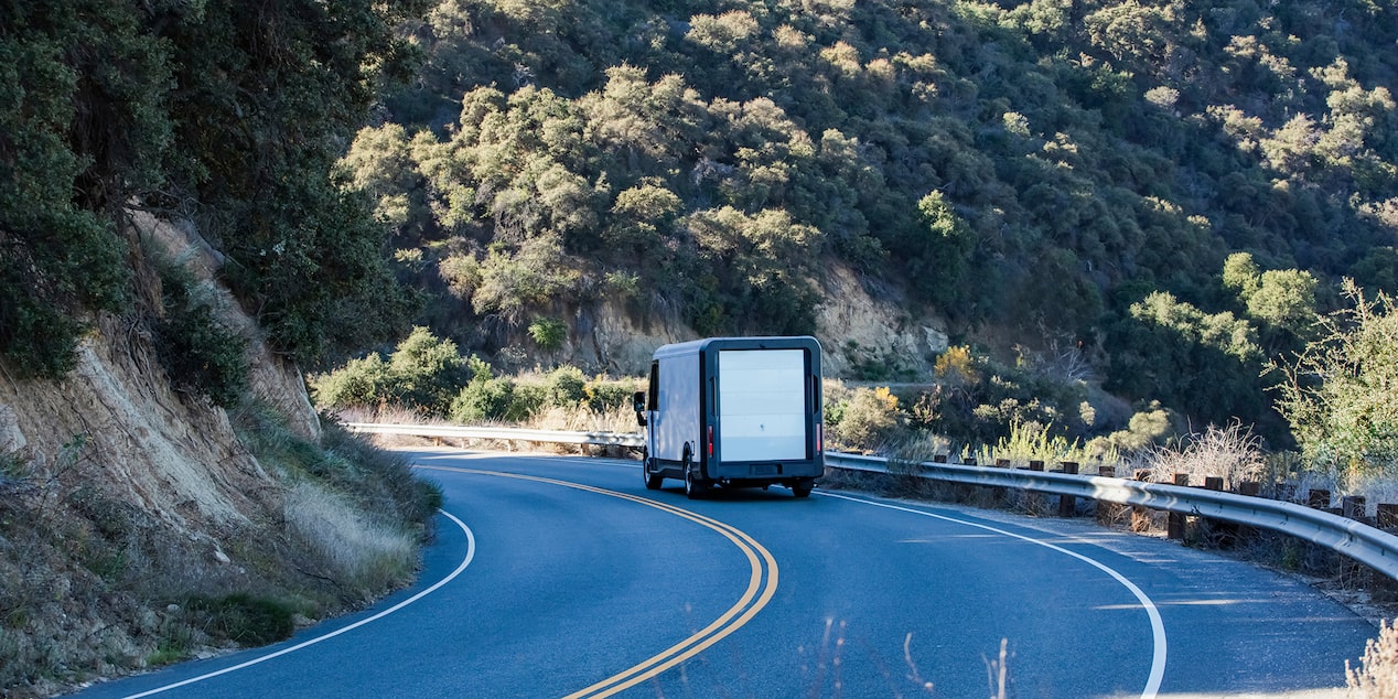 A Chevrolet BrightDrop driving on a winding road. 