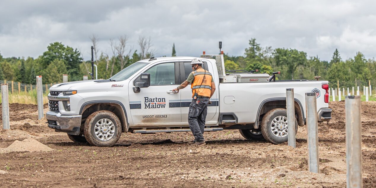 A custruction worker walking to their Barton Mallow branded Chevrolet Silverado