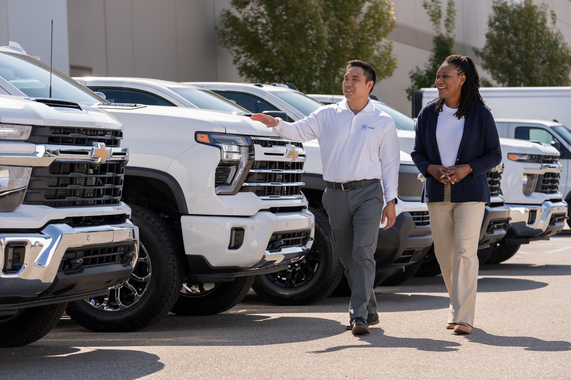 A GM Fleet employee showing a flee of Chevrolet Silverados to a customer. 