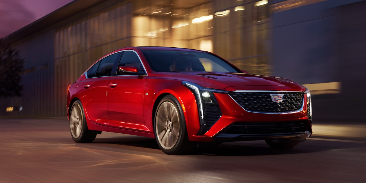 A red Cadillac CT5 driving down the road.