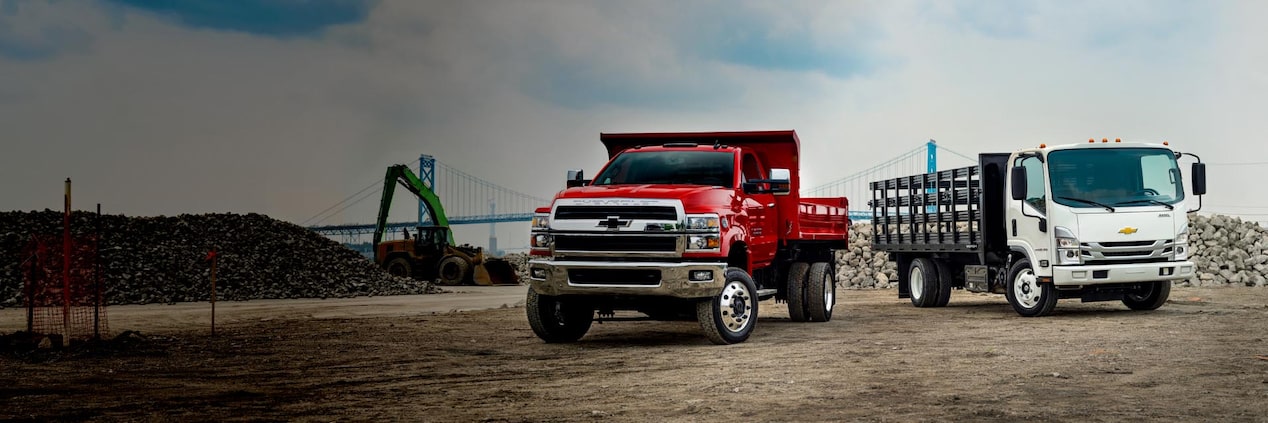 Two Chevrolet trucks parked on a jobsite