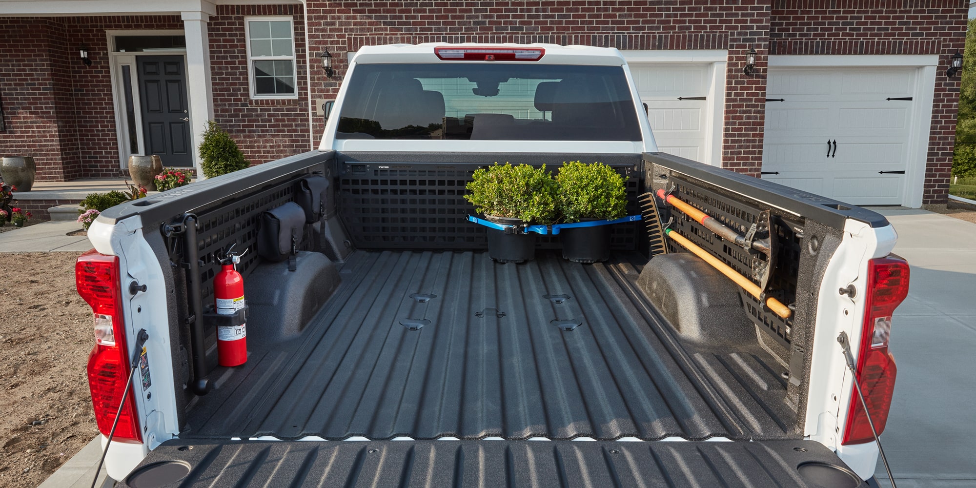 The bed of a 2026 Silverado HD with plants in the back right corner.