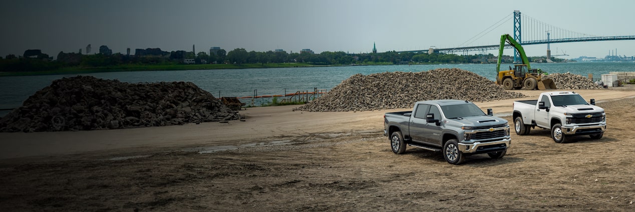 Two Chevrolet Silverado HDs parked on a jobsite