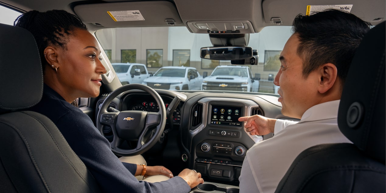 A GM Fleet sales associate showing the interior of a Silverado HD to a customer