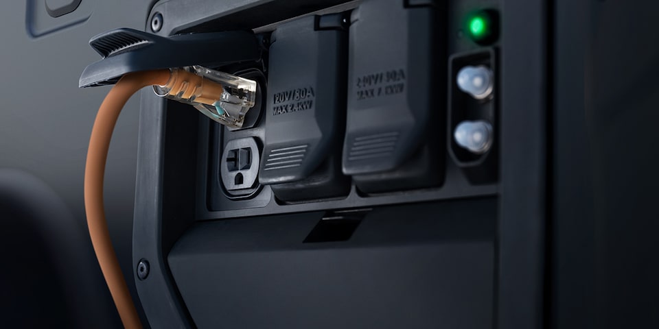 Close up of an extension cord plugged into the built in outlets on a Silverado EV