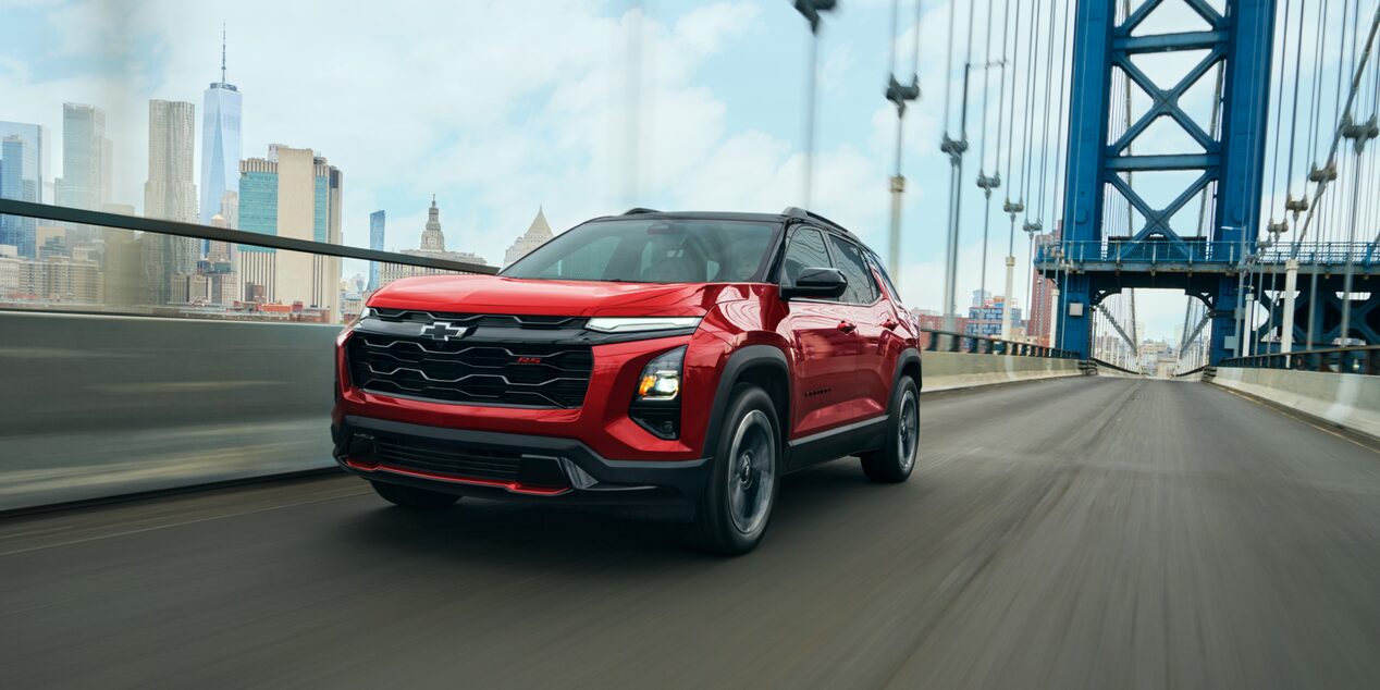 A red Chevrolet Equinox RS driving over a bridge. 