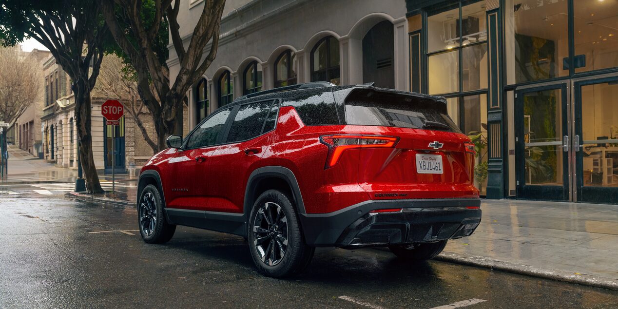 A Red Chevrolet Equinox parked in the rain. 