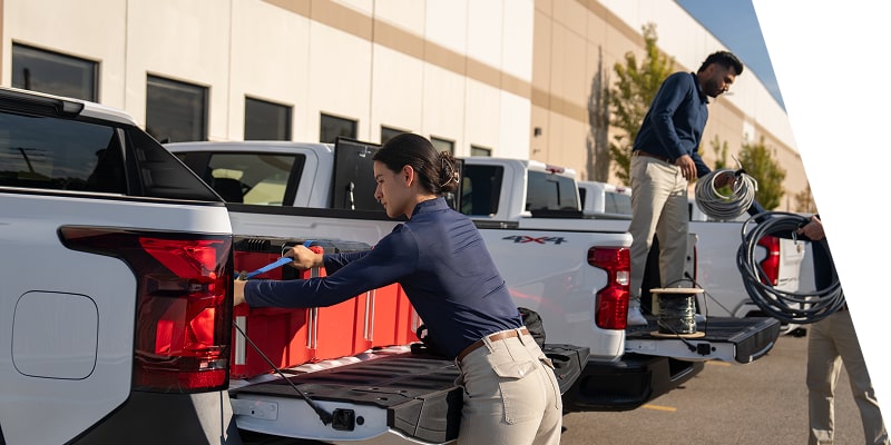Workers unloading equipment from the back of their Chevrolet Silverados