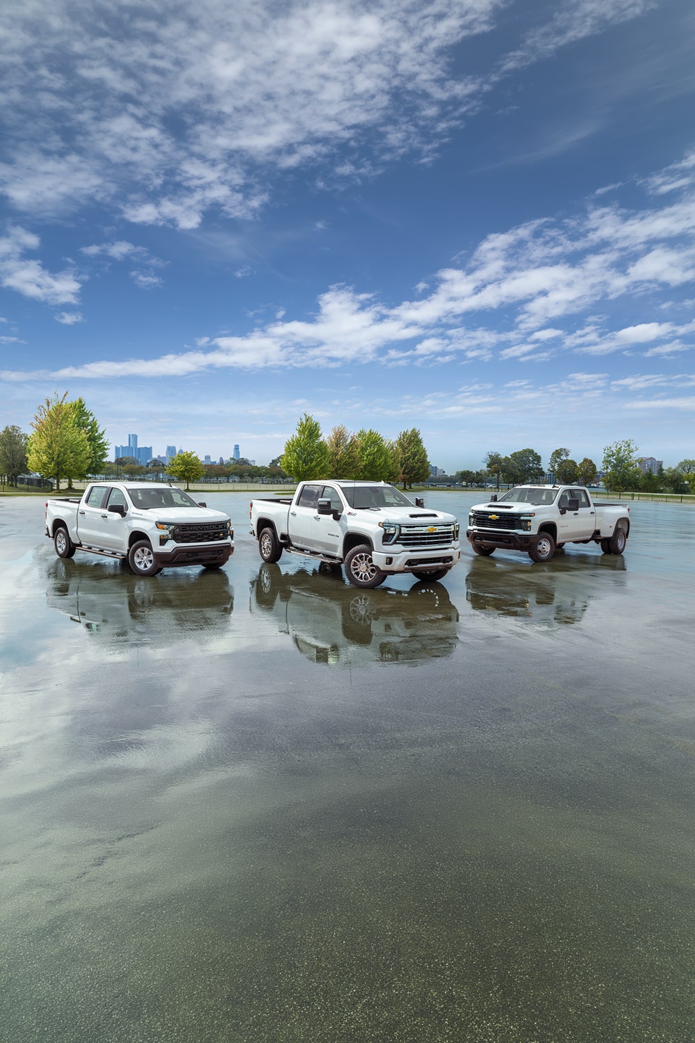 A Fleet of Chevrolet Silverados parked in a wet parking lot.