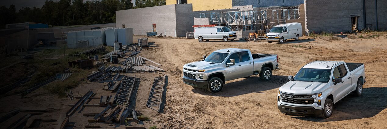 Two Chevrolet Silverados parked on a construction site