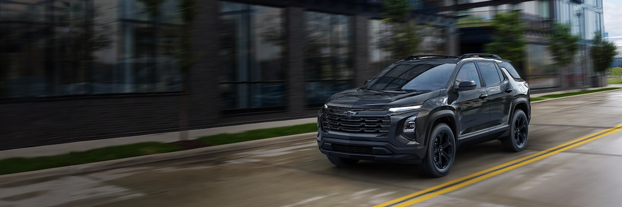 A Black 2026 Chevrolet Equinox driving down a street.
