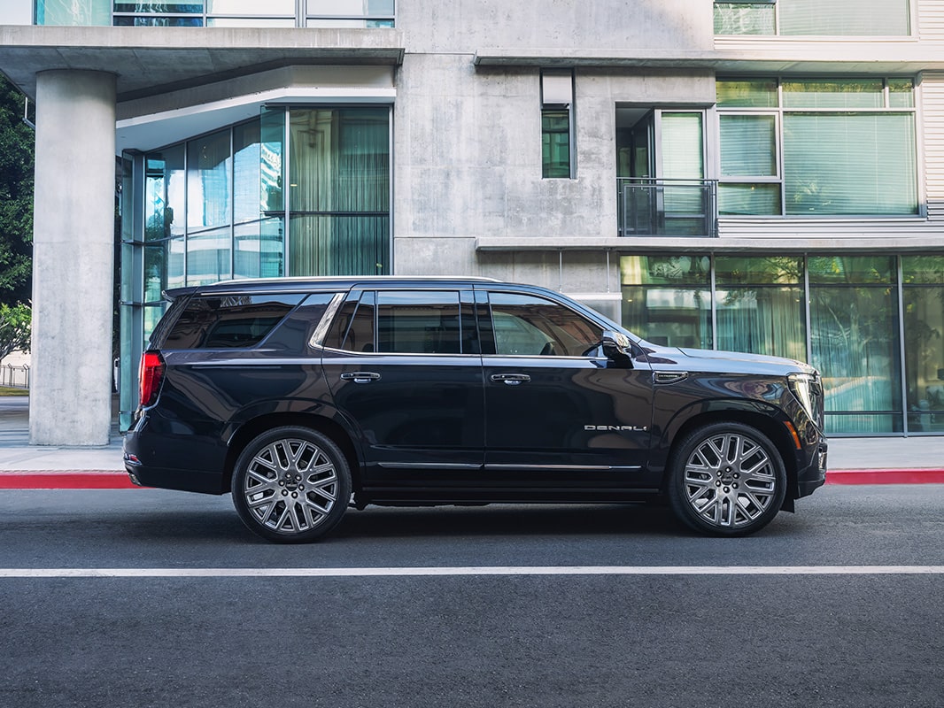A right-side view of a 2026 GMC Yukon parked in front of a building