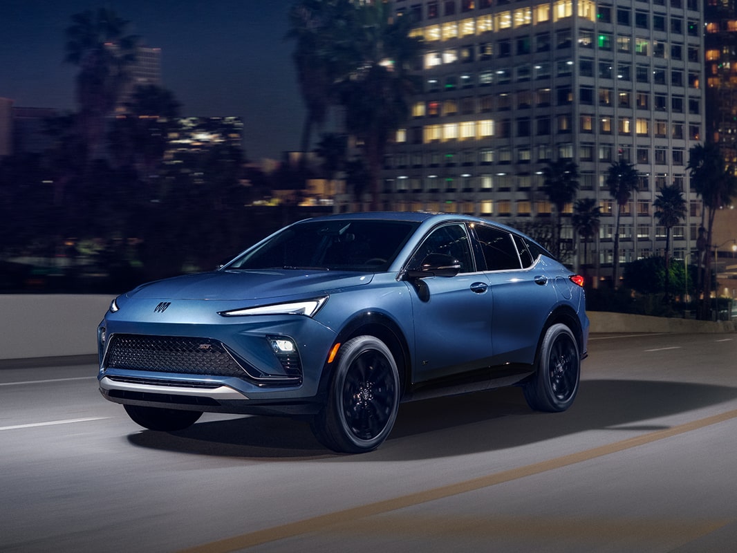 A 2026 Buick Envista driving down a city street at night