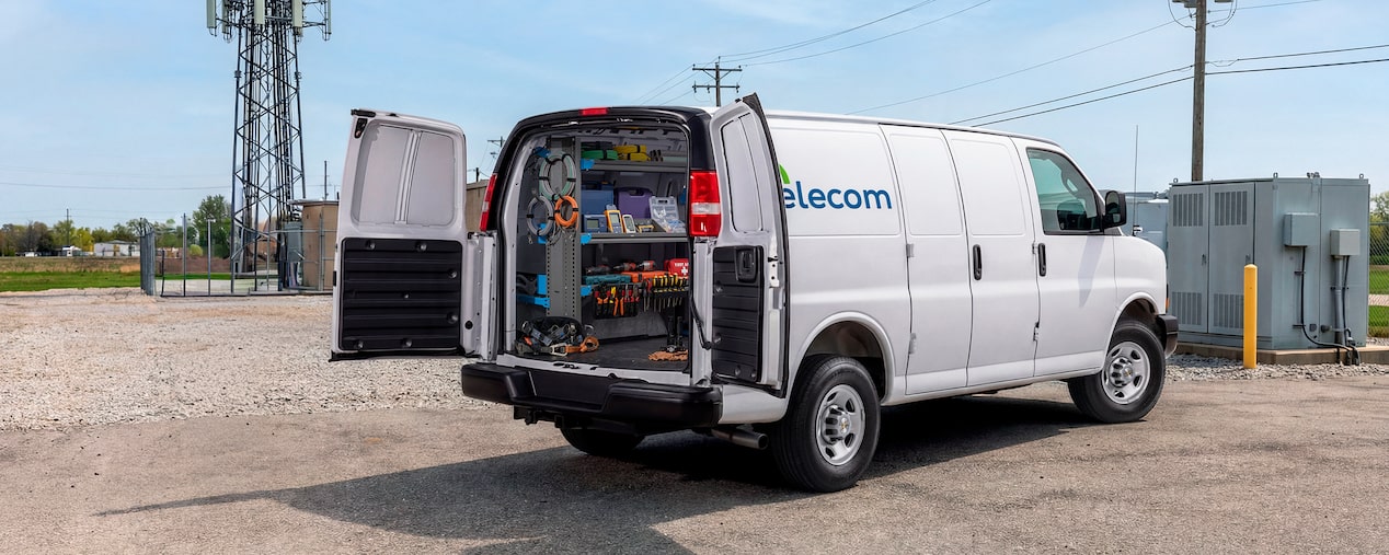 A white Chevrolet Express Cargo Van customized for telecom