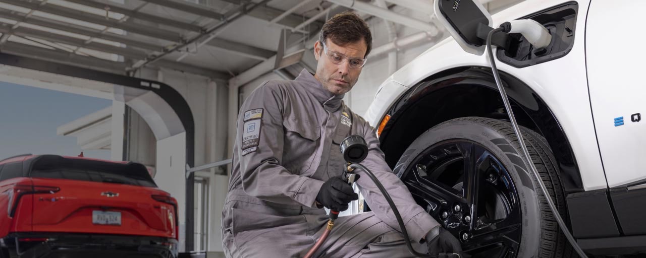 A mechanic servicing an electric fleet vehicle