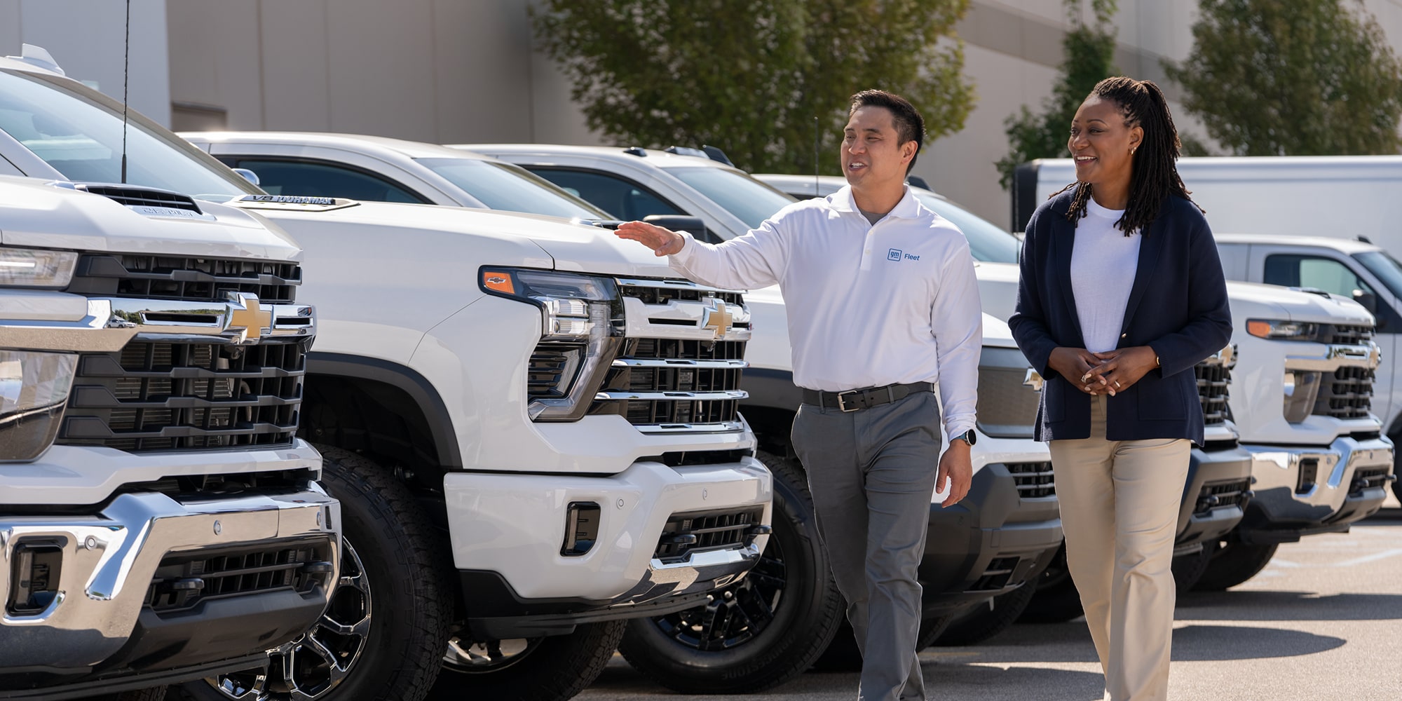 A GM Fleet sales representative showing a customer a fleet of Chevrolet Silverados