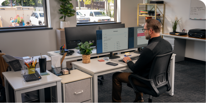An Office worker at their desk using OnStar Vehicle Insights
