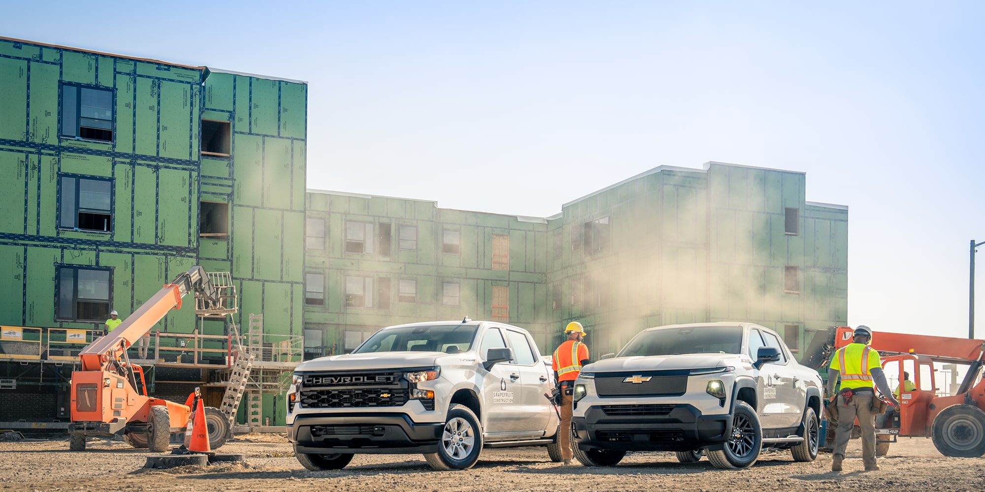 Two Chevrolet Silverados parked on a construction site.