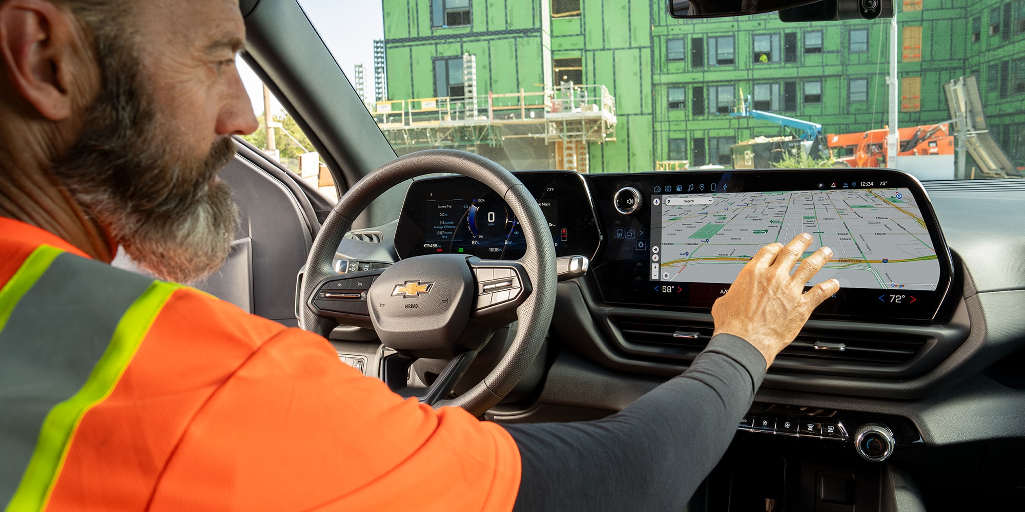 A construction worker using the infotainment system of their Chevrolet Silverado