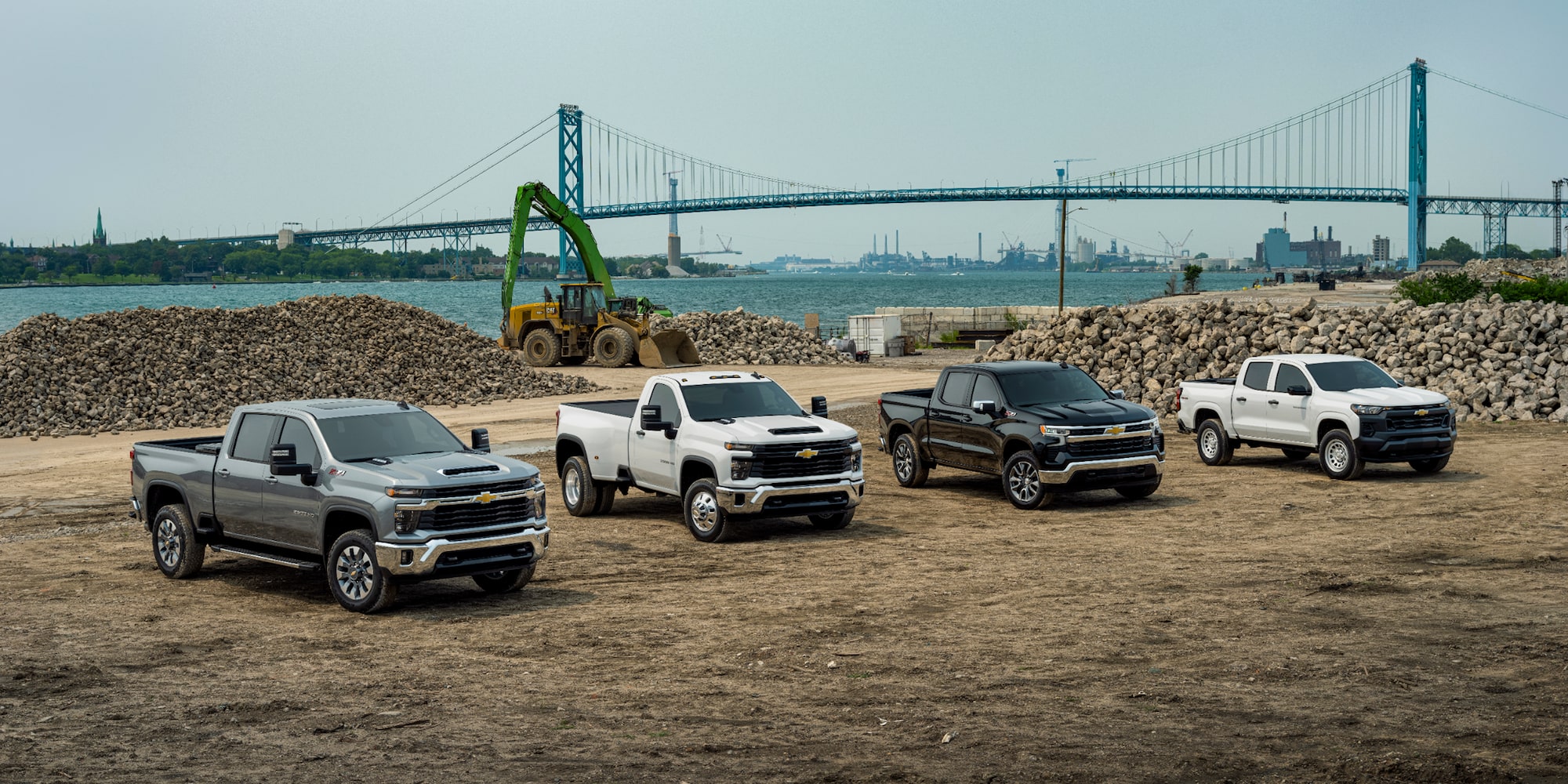 A group of 4 Chevrolet Silverados on a jobsite near a bridge