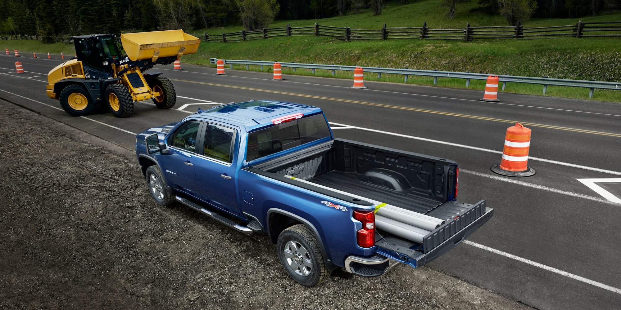 A blue Chevrolet Silverado HD parked on the side of the road with it's tailgate open. 