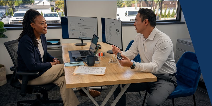A GM Fleet sales associate discussing the benefits of the OnStar Fleet Adaptor with a customer.