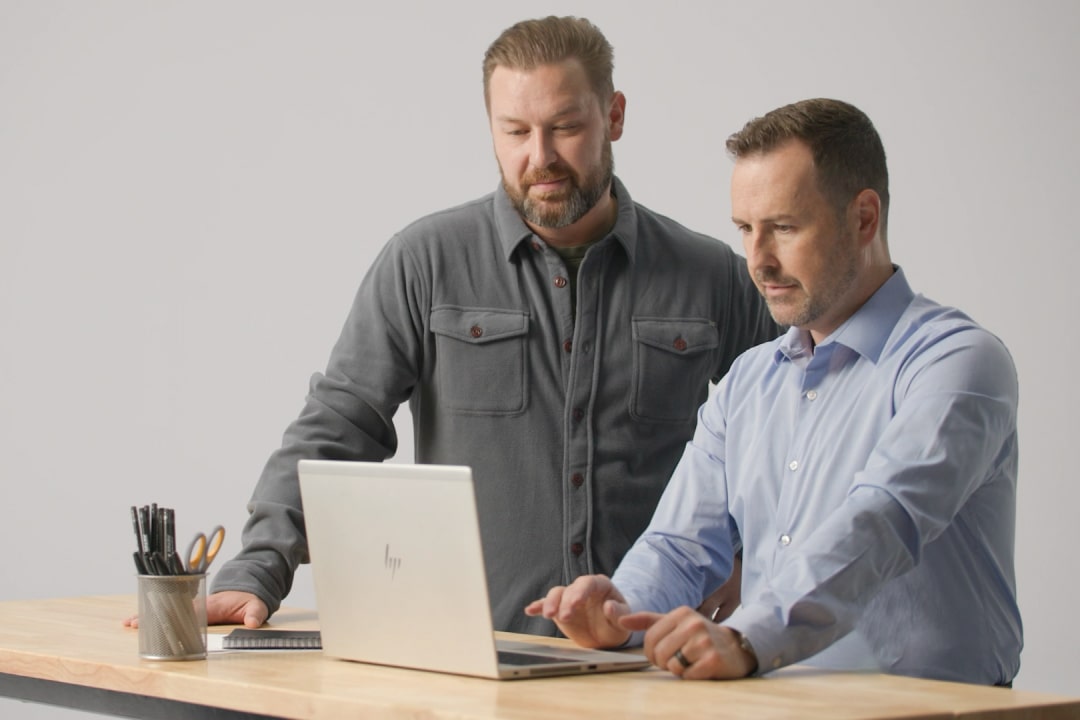 Two men working on a laptop