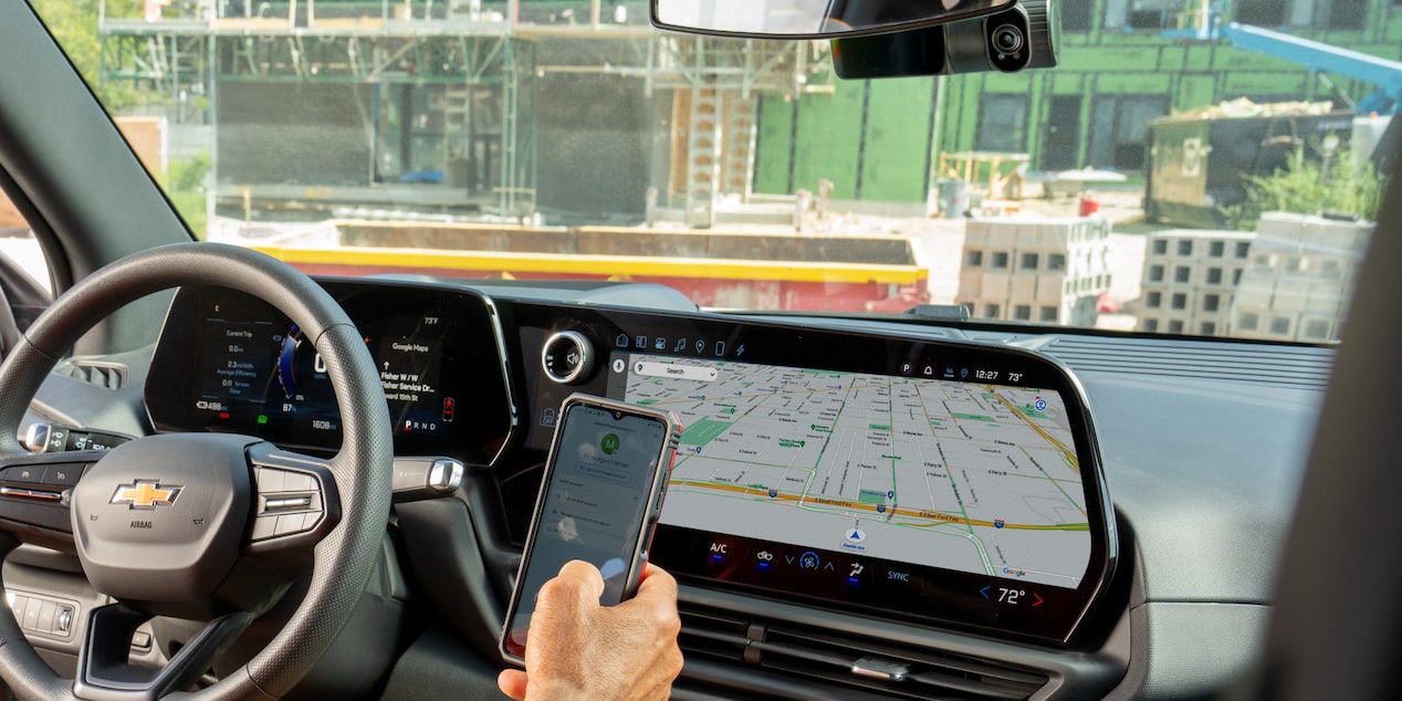 A driver using their GM Fleet connect mobile app in their Chevrolet Silverado.