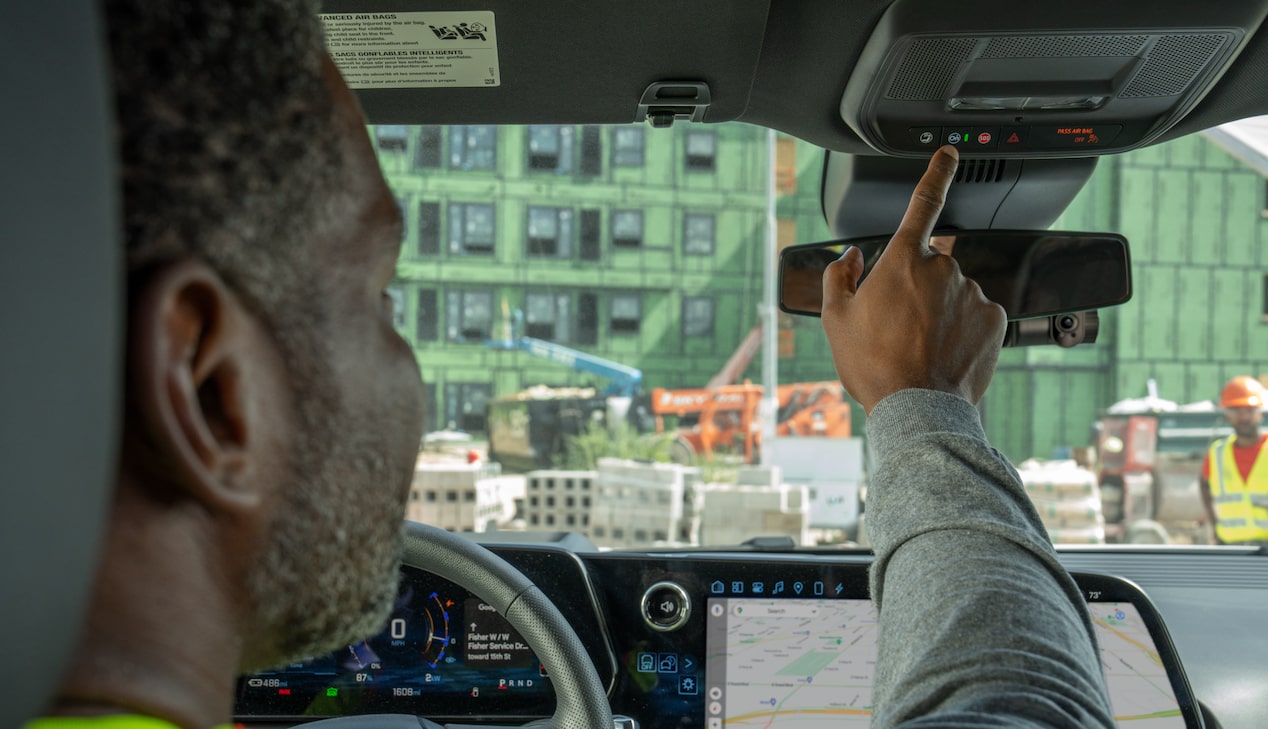 A driver pushing the OnStar button in their Chevrolet Silverado.