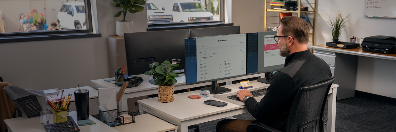 An office worker at their desk with OnStar One Fleet on their monitor