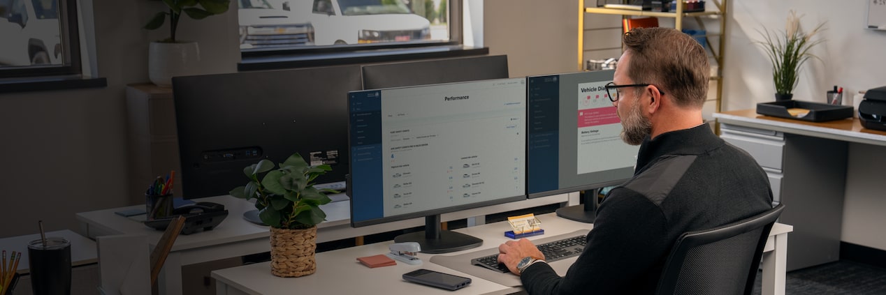 An office worker at their desk with OnStar One Fleet on their monitor
