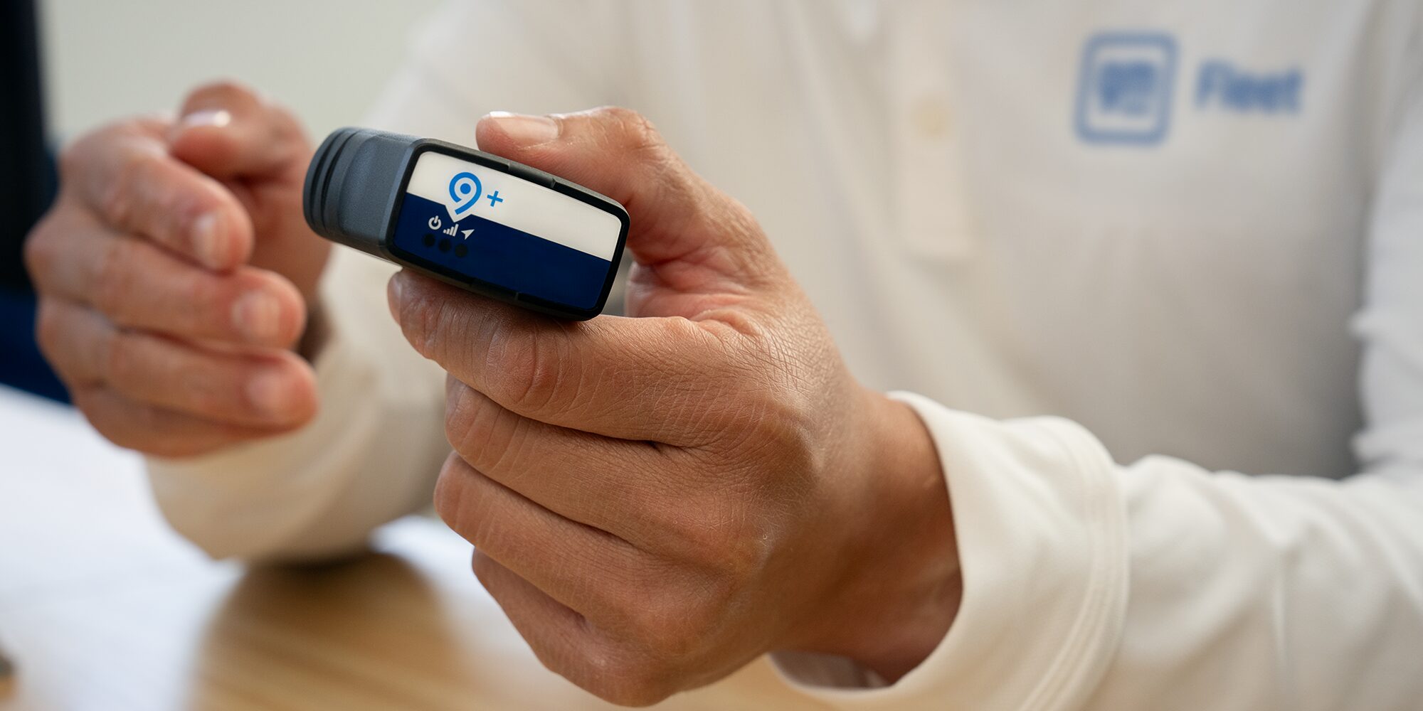 An OnStar fleet adapter being held by a GM Fleet employee.