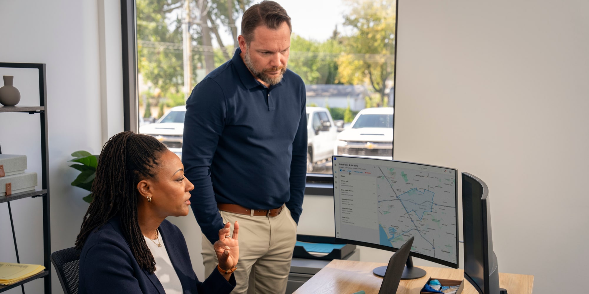 Two office workers viewing GM Fleet Telematics.