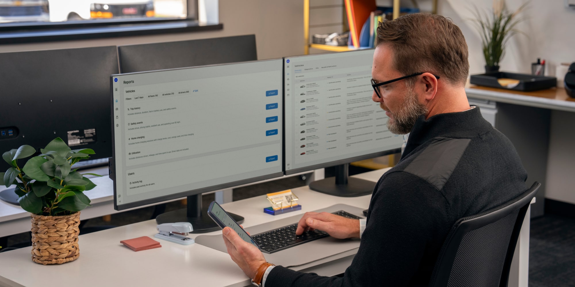An office worker using GM Fleet telematics on his phone and computer.