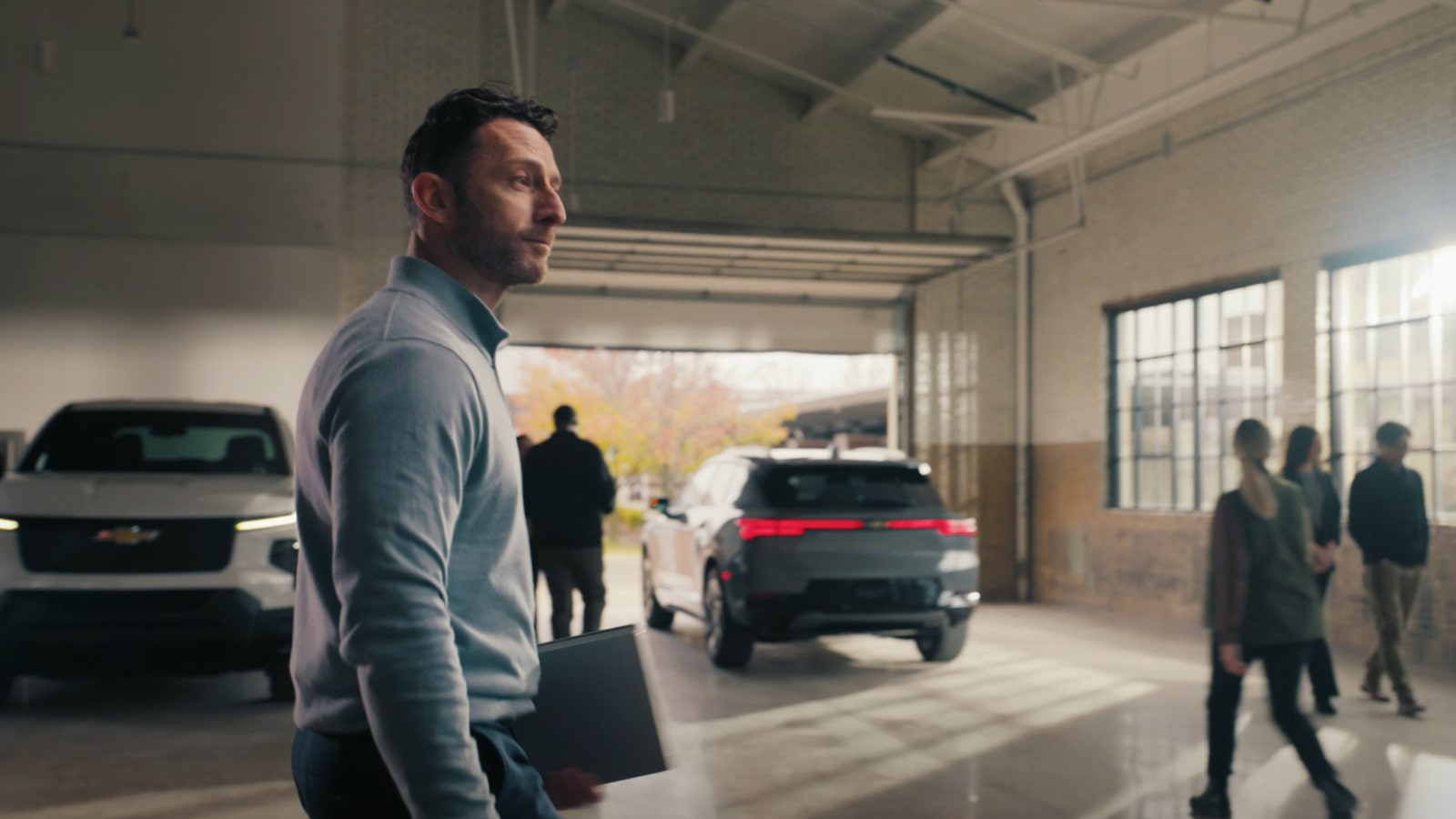 a video thumbnail showing a man walking in front of two Chevrolet EVs
