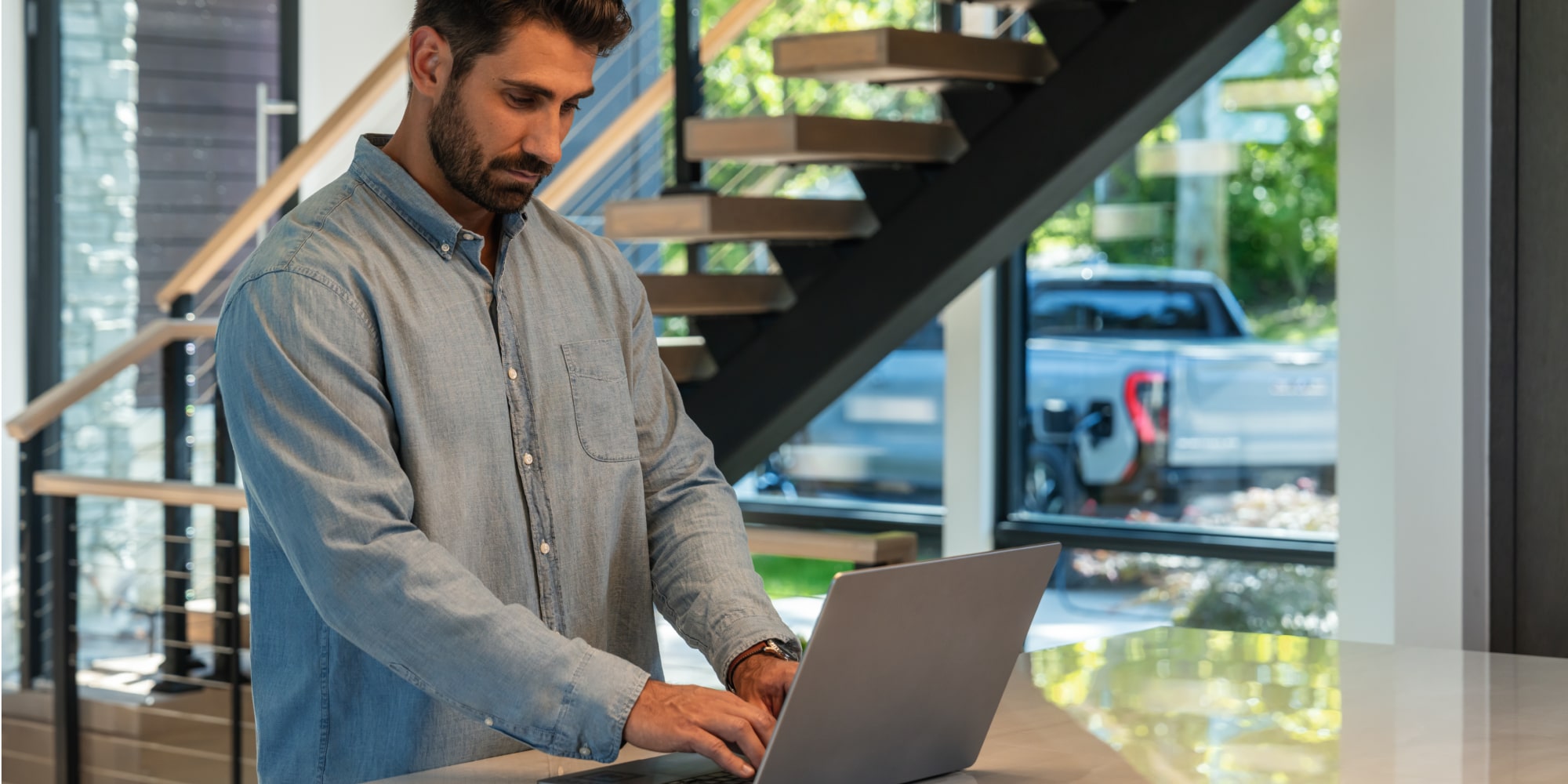 An office worker using GM Fleet telematics on his laptop.