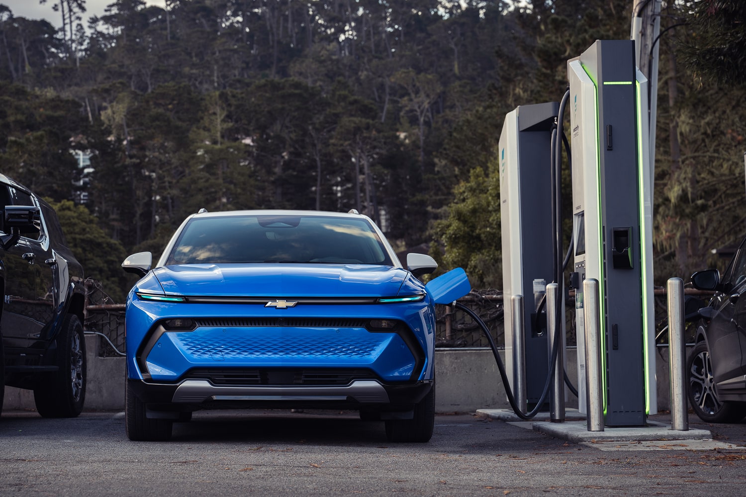 A Blue Chevrolet Blazer EV parked at an EV charger viewed from the front. 