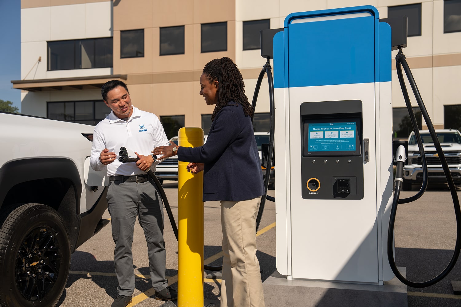 A GM Fleet worker showing how to use a charging station.